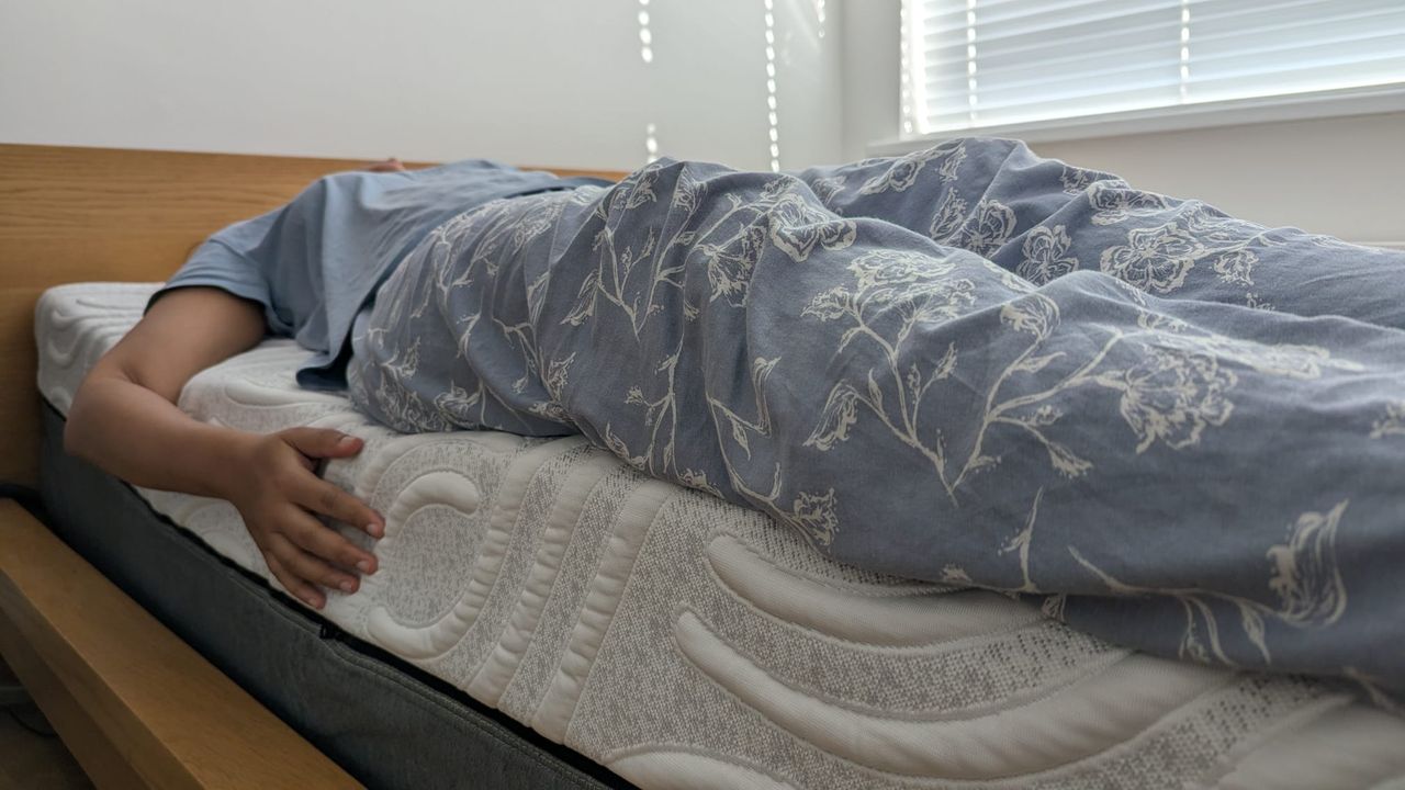 Our tester assessing the edge support of the mattress in a brightly lit room