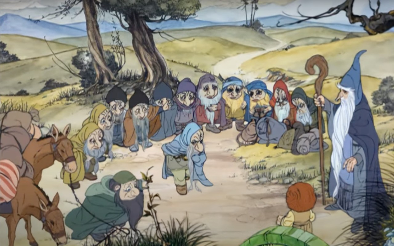 A group of bowing Hobbits surrounding Bilbo and Gandalf during a meeting.