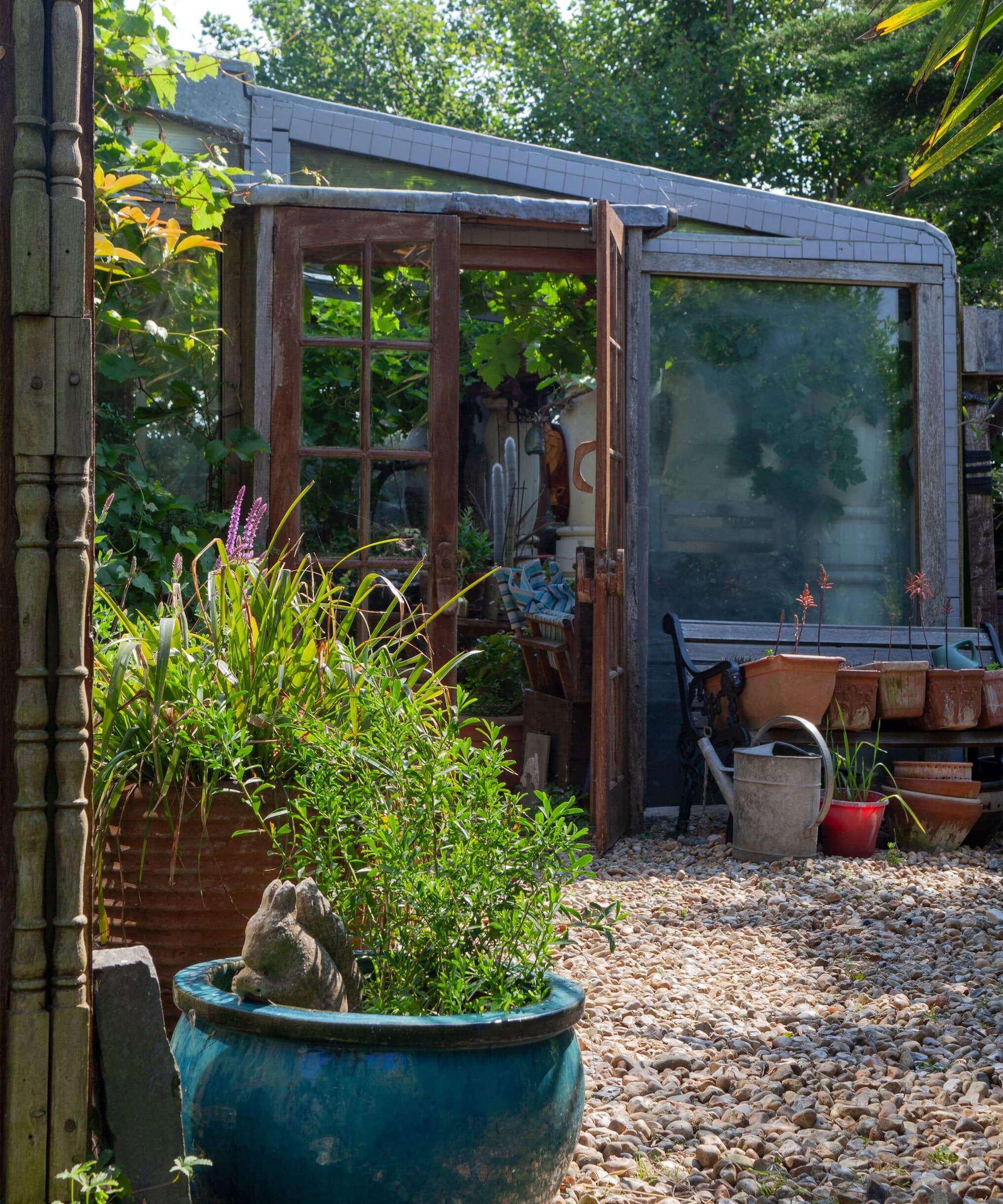 A gravelled garden leading to a garden room