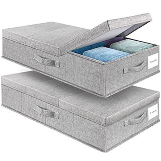 Two grey rectangular under bed storage boxes, fabric. One open showing green and blue fodled items