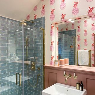 Pink pineapple print wallpaper in bathroom with turquoise tiled shower