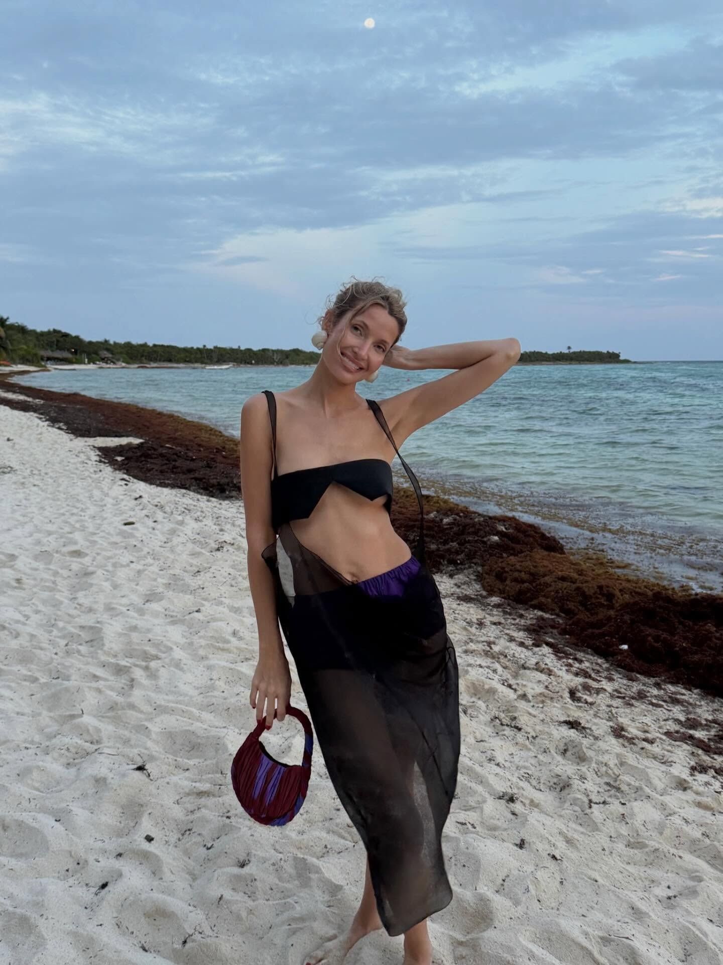 Woman holding a burgundy handbag.