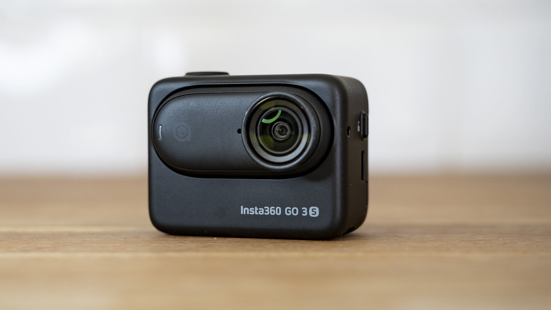 Insta360 Go 3S camera in its housing on a wooden surface