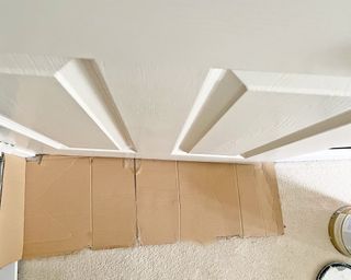 Cardboard placed under an internal door to protect the floor before painting