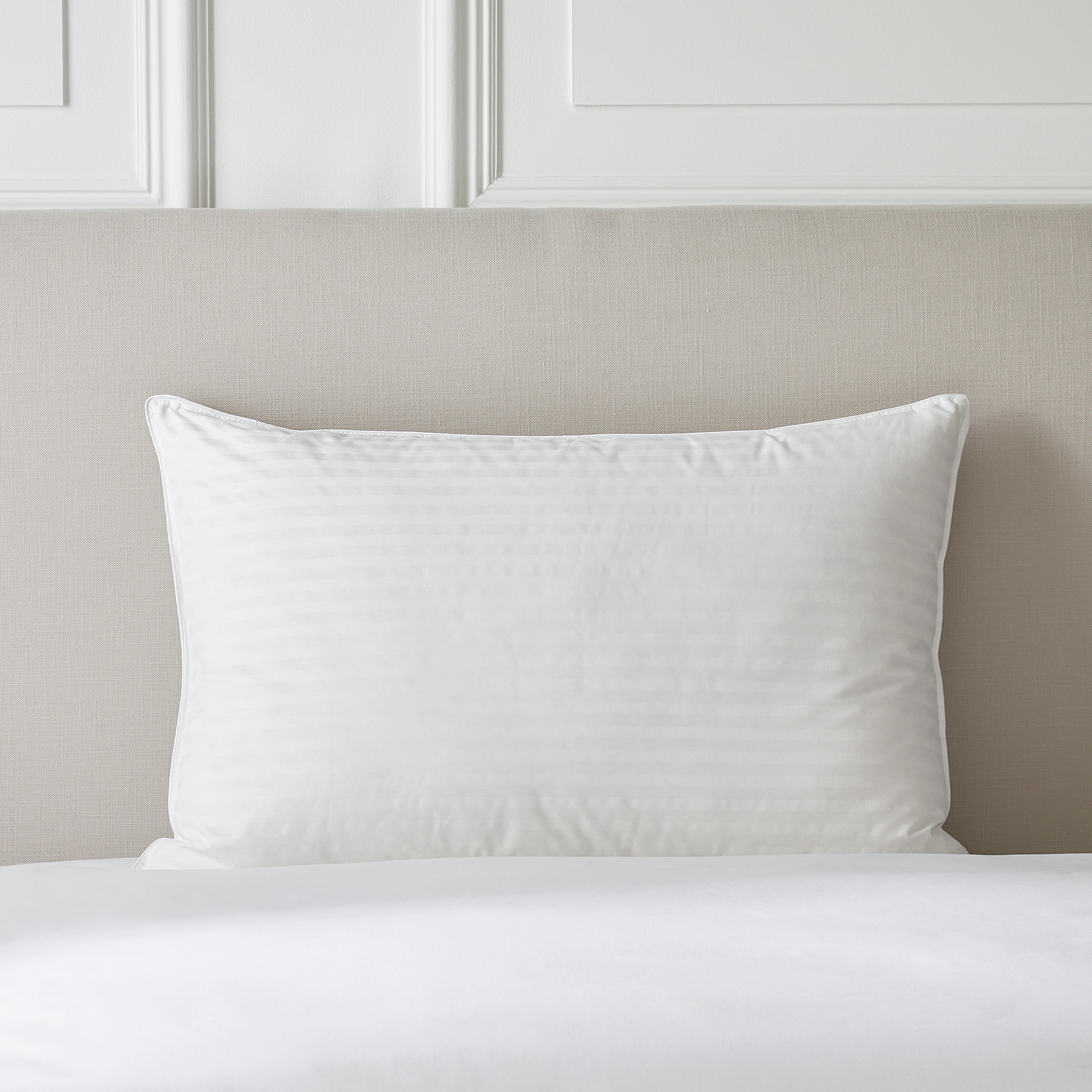 A white pillow on a bed