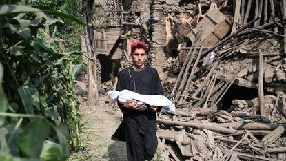 Afghan teen carries the body of a relative killed in an earthquake