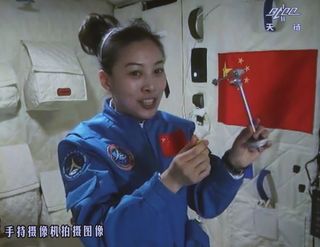 This screengrab from television taken on June 20, 2013 shows female astronaut Wang Yaping, one of the three crew members of Shenzhou-10 spacecraft, giving a lecture to students on Earth aboard China's space module Tiangong-1.