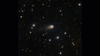 A streak of white shows interstellar comet 3I/ATLAS in the center of a starry night sky