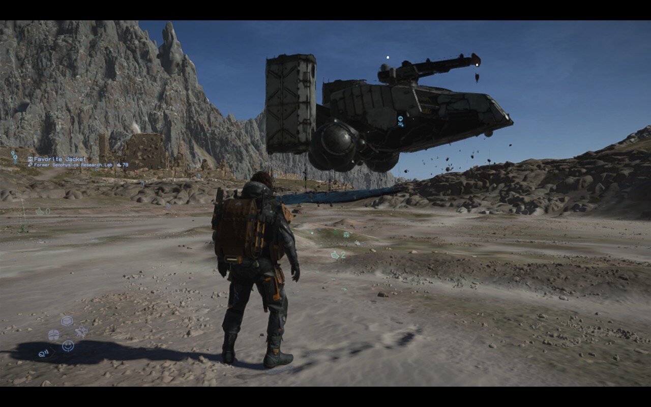 A man watches as a sci-fi vehicle takes flight in a dry desert environment