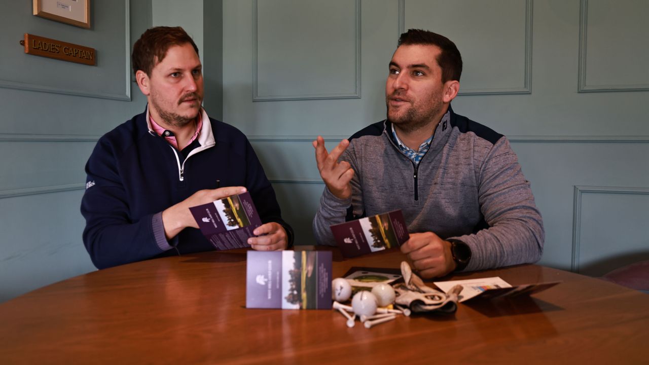 two golfers going over their scorecards in the clubhouse after a round of golf