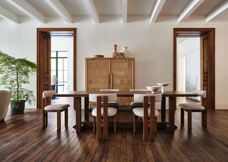 A neutral dining room with a wooden dining table and boucle chairs