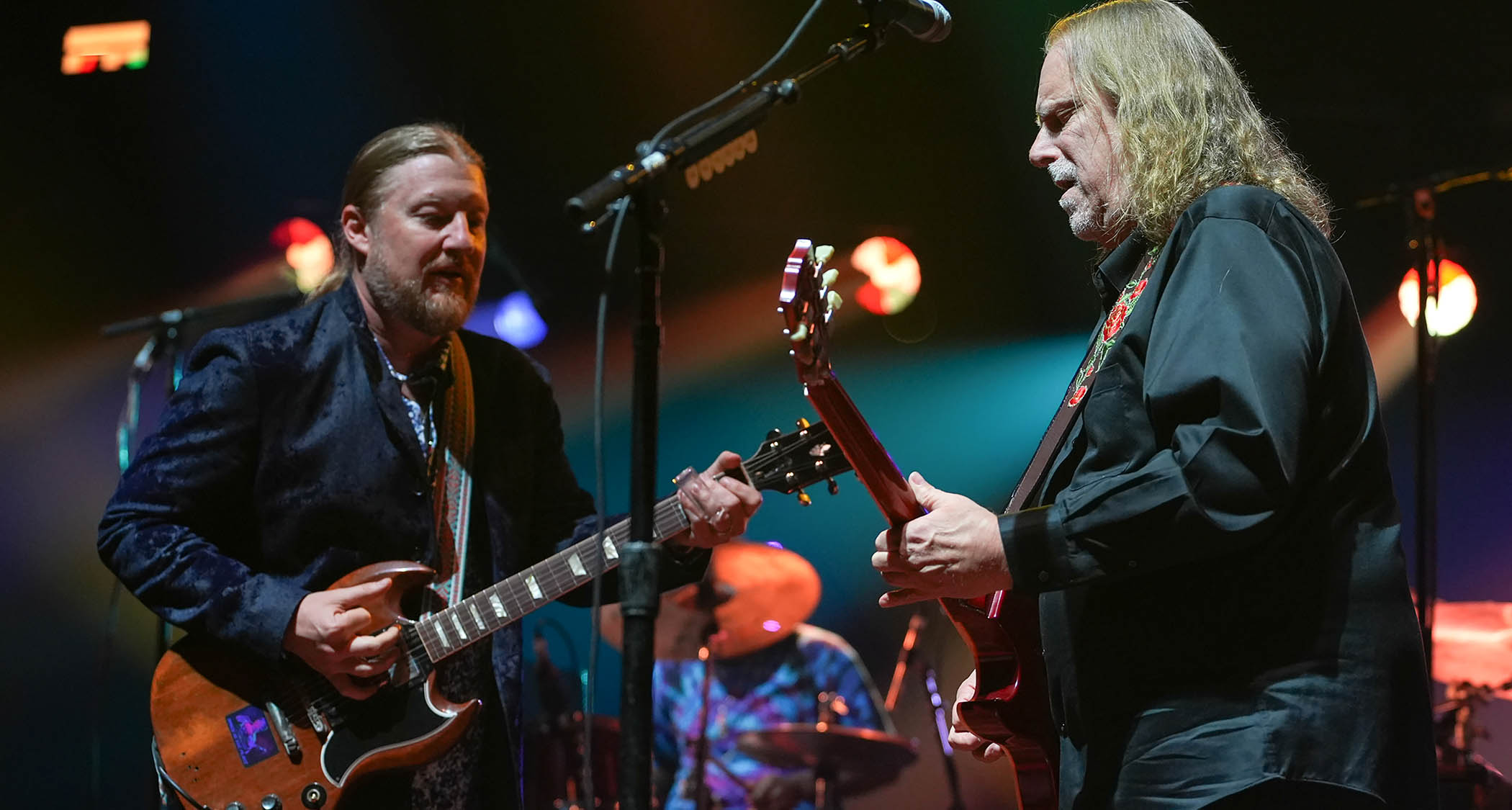 Derek Trucks and Warren Haynes jam onstage in 2025, with Trucks playing a Gibson SG and Haynes playing a Les Paul.