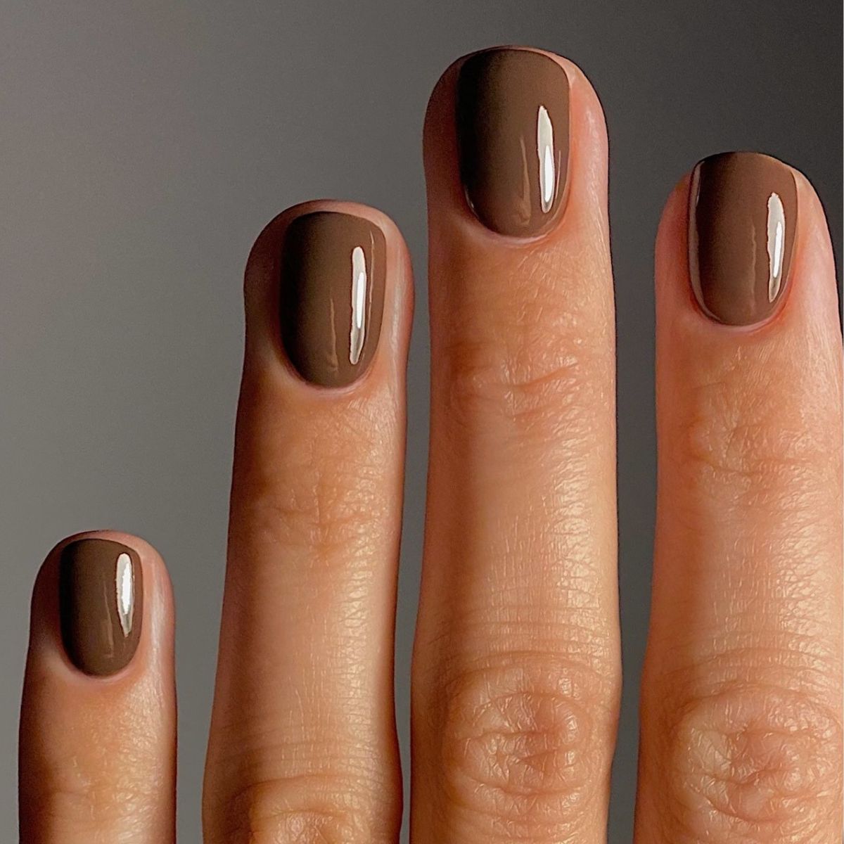 A close-up of @matejanova's hand, with her nails painted in Manucurist's Mocha nail polish shade