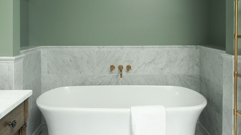 Pale green bathroom with white marble sanitary ware and arched wall