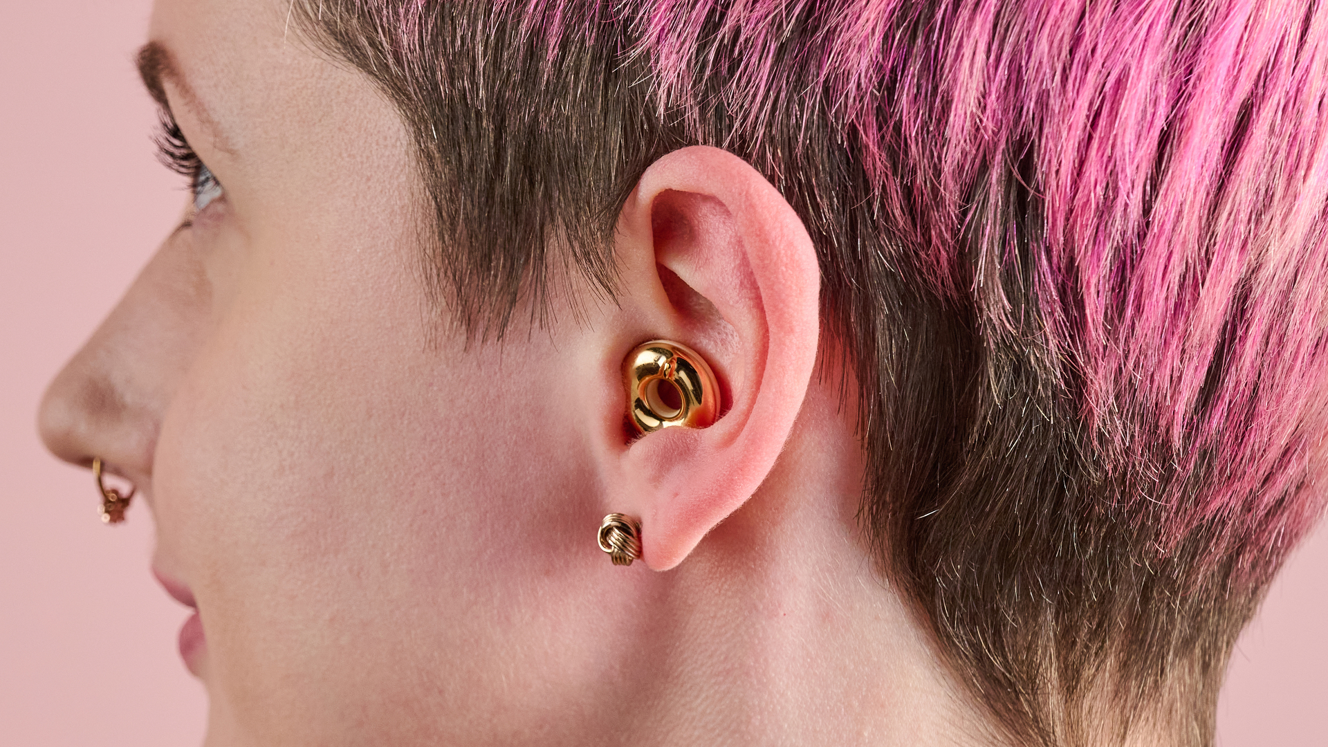 A side view of a woman modeling the Loop Switch 2 in gold.