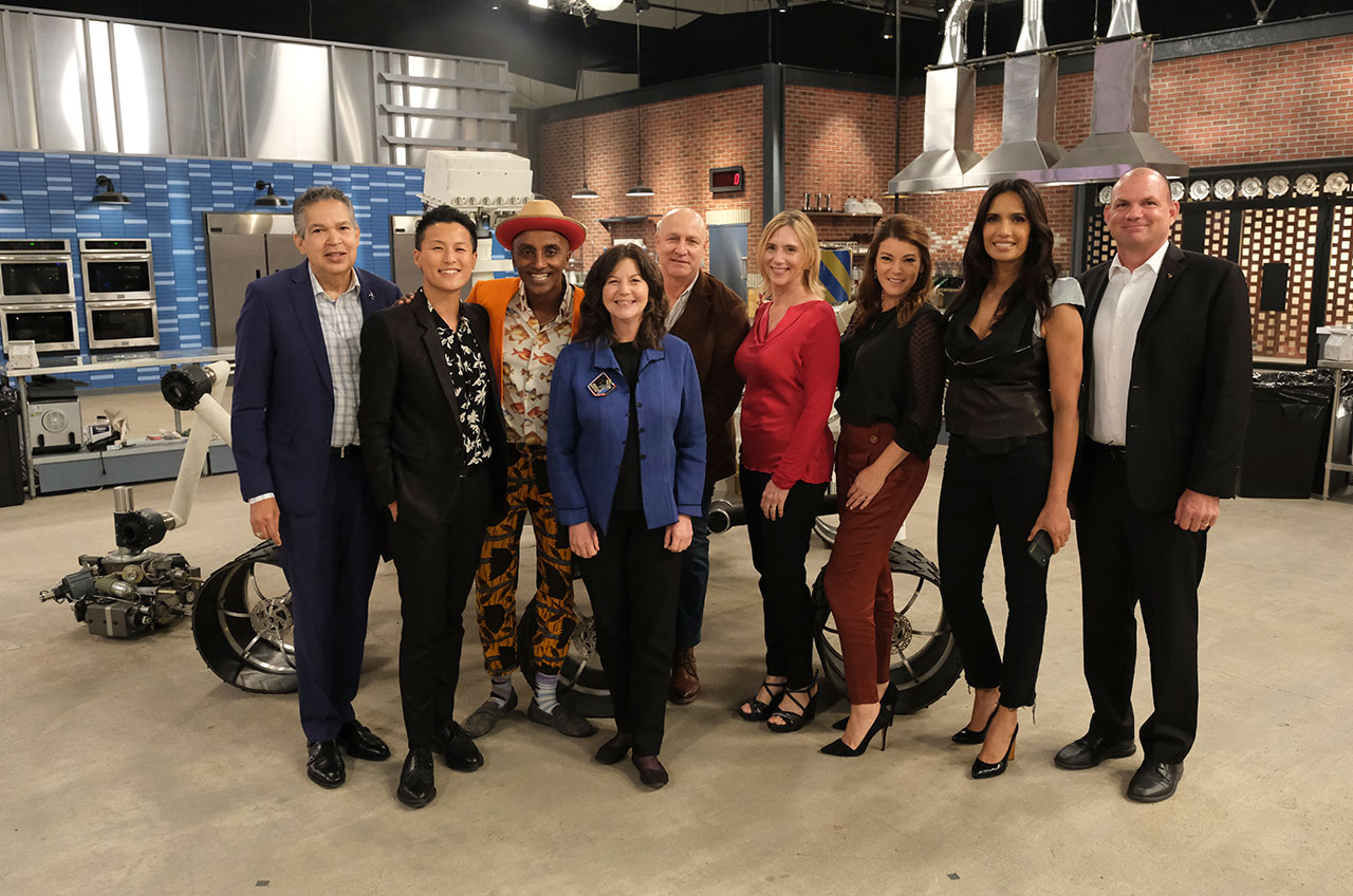 Astronauts Cady Coleman (fourth from left), Susan Kilrain (fourth from right) and Tony Antonelli (at right) join Space Center Houston CEO William Harris, chefs Melissa King, Marcus Samuelsson, Tom Colicchio and Gail Simmons and host Padma Lakshmi on the Top Chef Houston set.