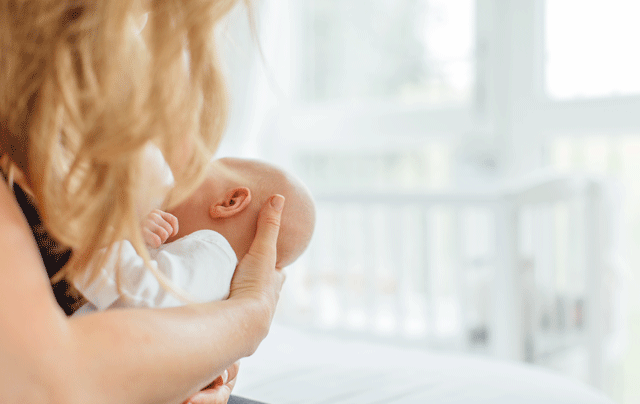 Blonde woman breastfeeding her baby