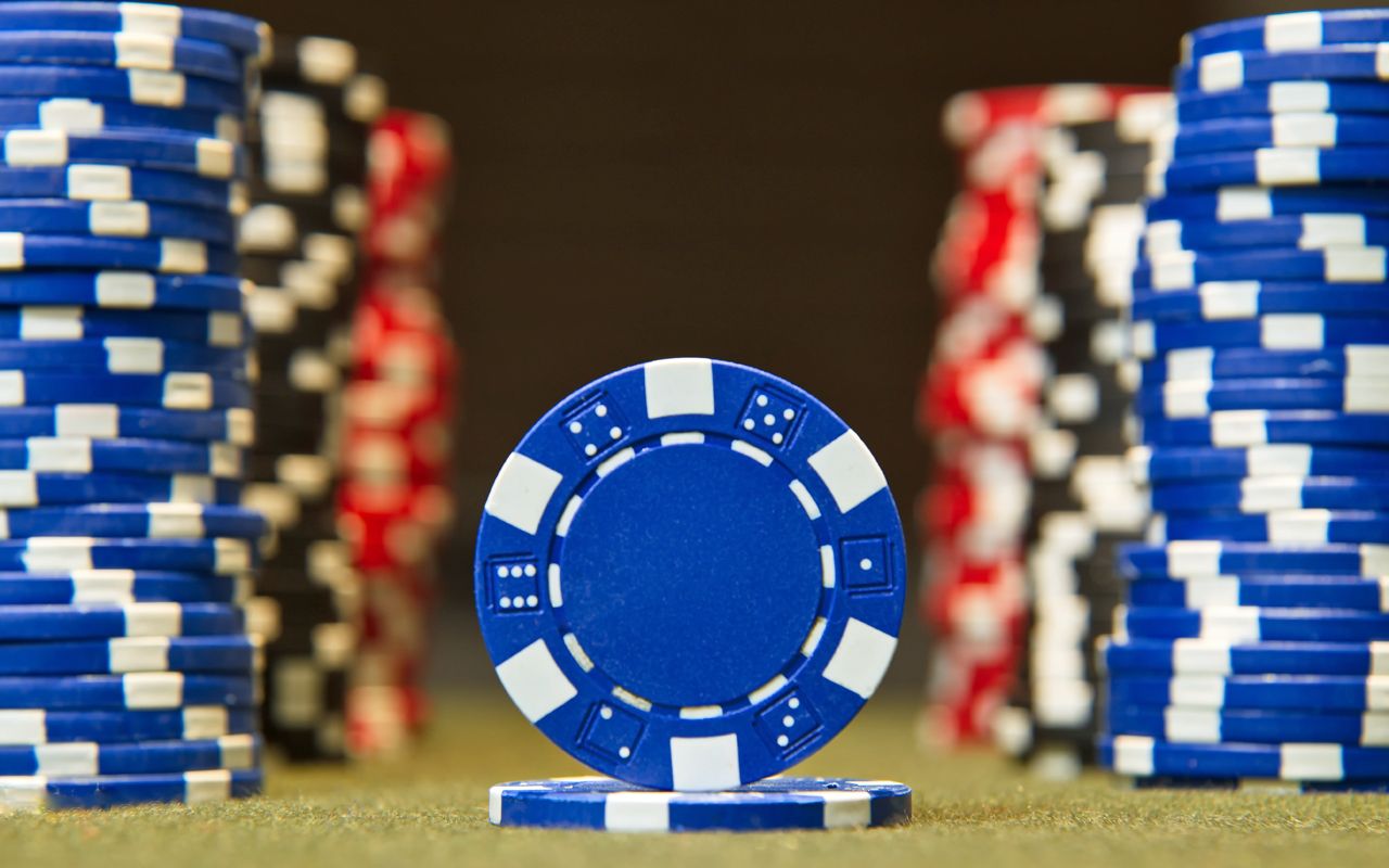 Closeup of poker chips on red felt card table surface