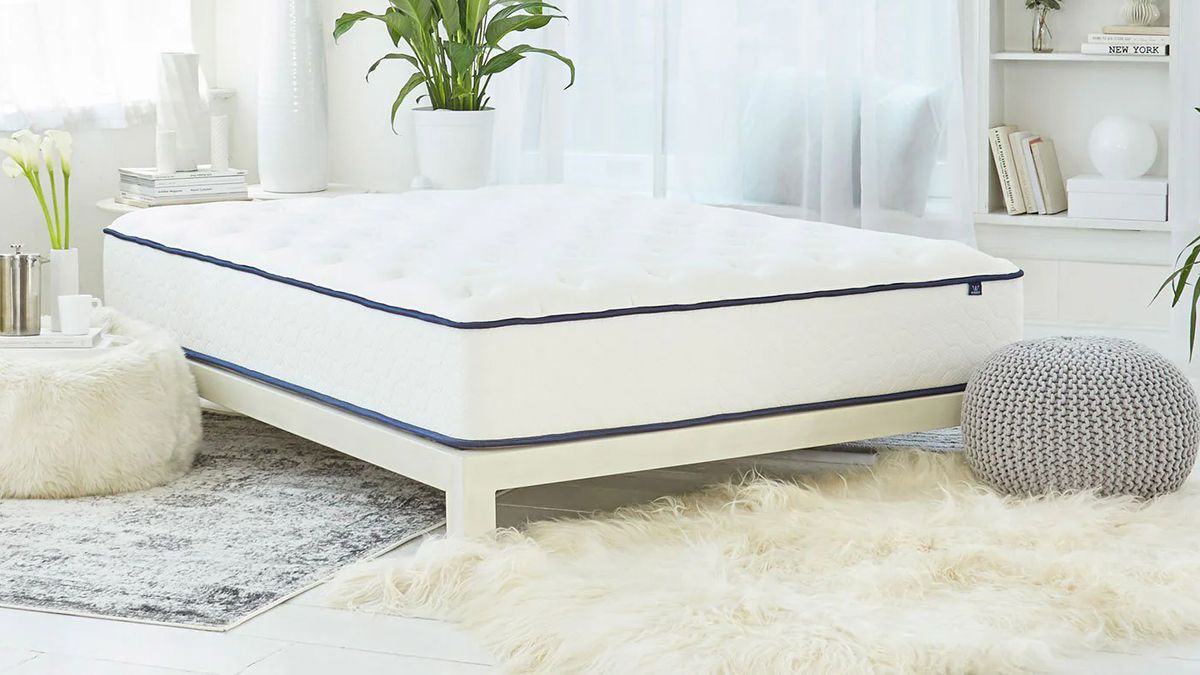 The WinkBed GravityLux mattress on a white bed frame in a bedroom