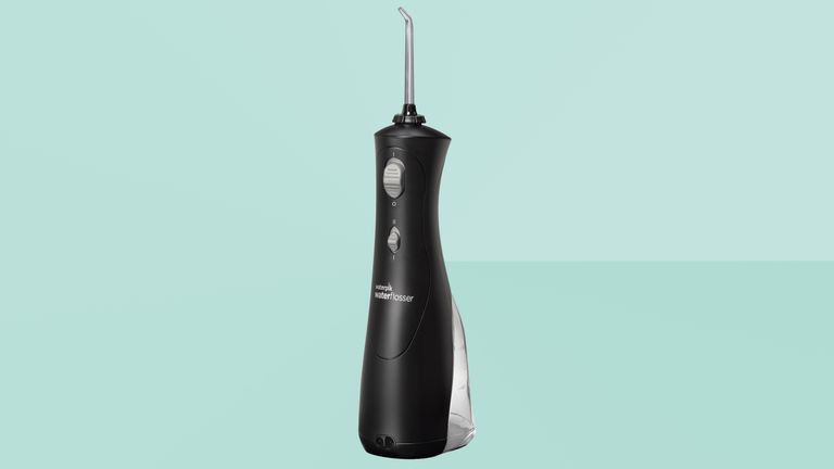 Water flosser from Waterpik on a green background