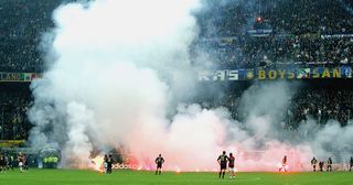 Inter fans shower the pitch with flares during the UEFA Champions League quarter-final second leg between AC Milan and Inter Milan at the San Siro Stadium on April 12, 2005 in Milan, Italy.