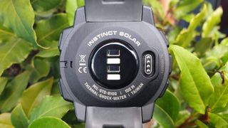 Close-up of Garmin Instinct Solar showing rear sensors and details of shock and water resistance