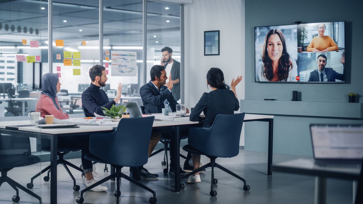 People on a videoconferencing call in a meeting room.