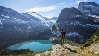 A man standing above a lake in Glacier National Park