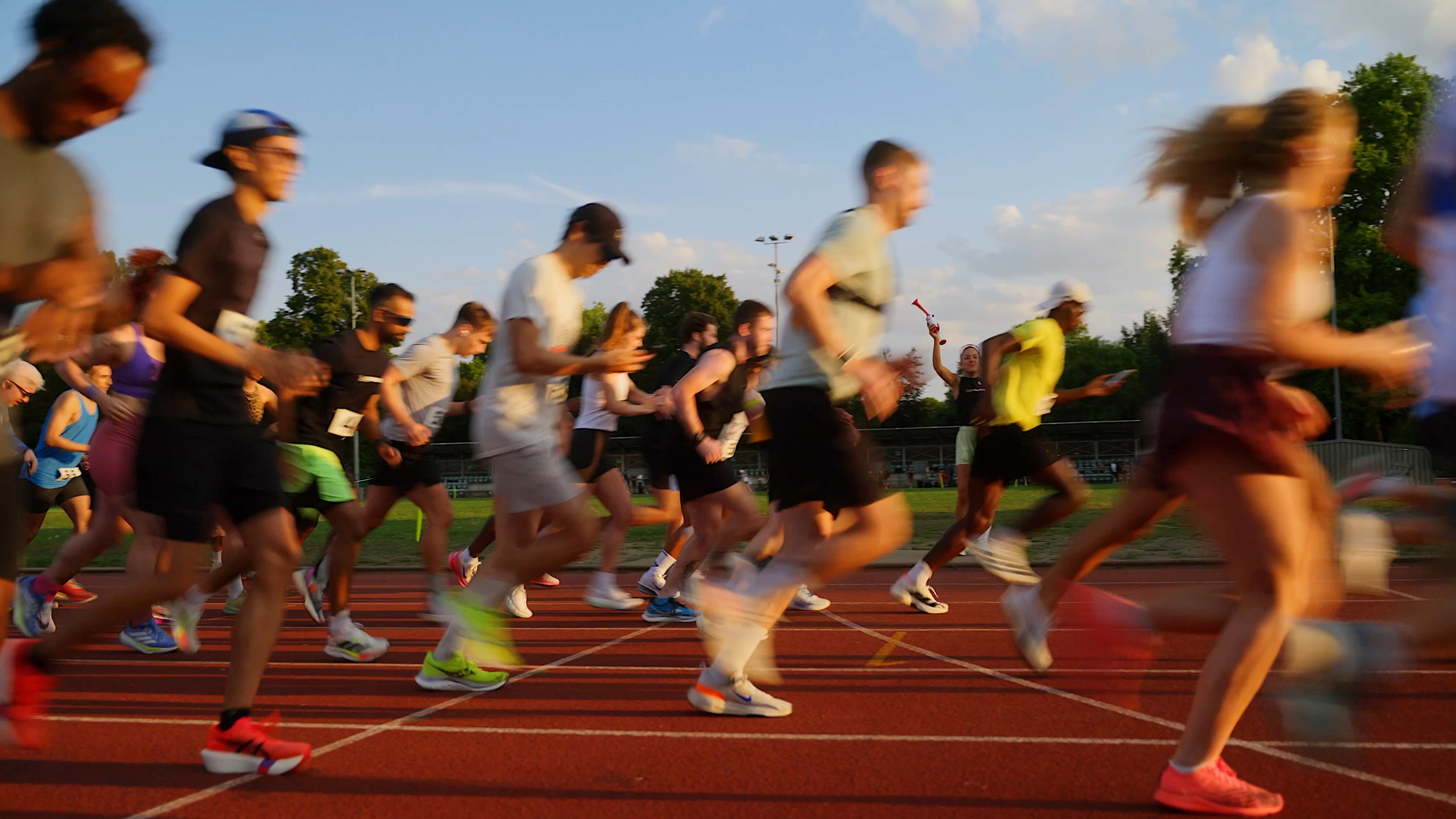 Group of people running on running track, there is motion blur on the image