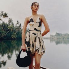 Model wearing net-a-porter dress in front of tropical river