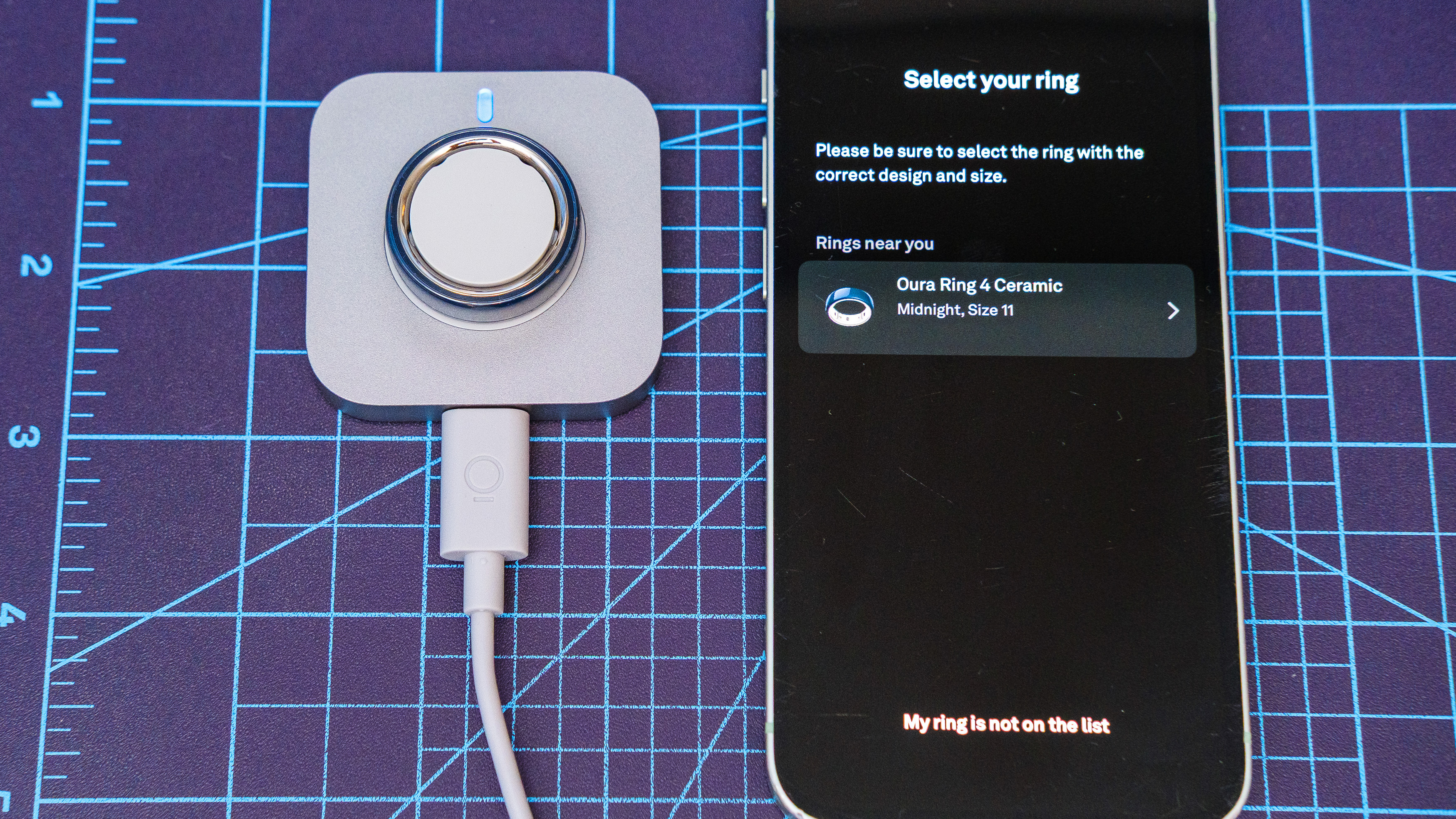 Oura Ring 4 Ceramic close-up showing the setup and pairing process using an iPhone