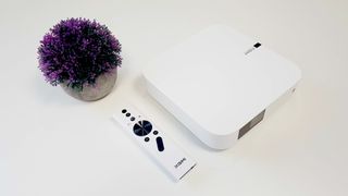 Xgimi Elfin projector top down with controller and a pot plant