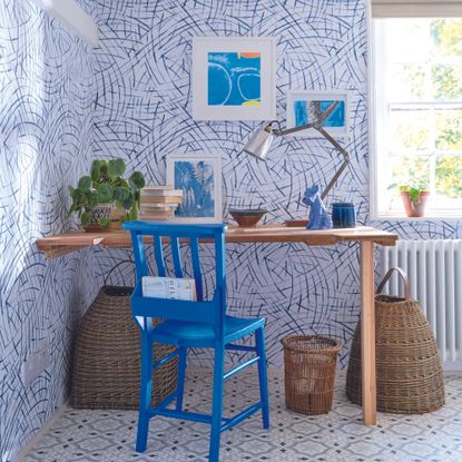Home office with blue wallpaper and blue patterned flooring.