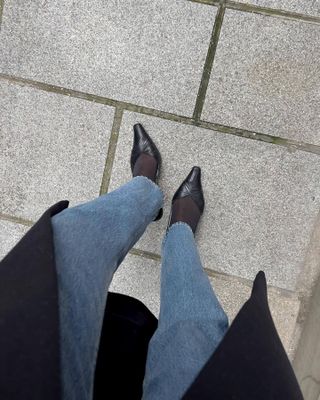 Sylvie wears straight-leg jeans, sheer tights, and black slingbacks.