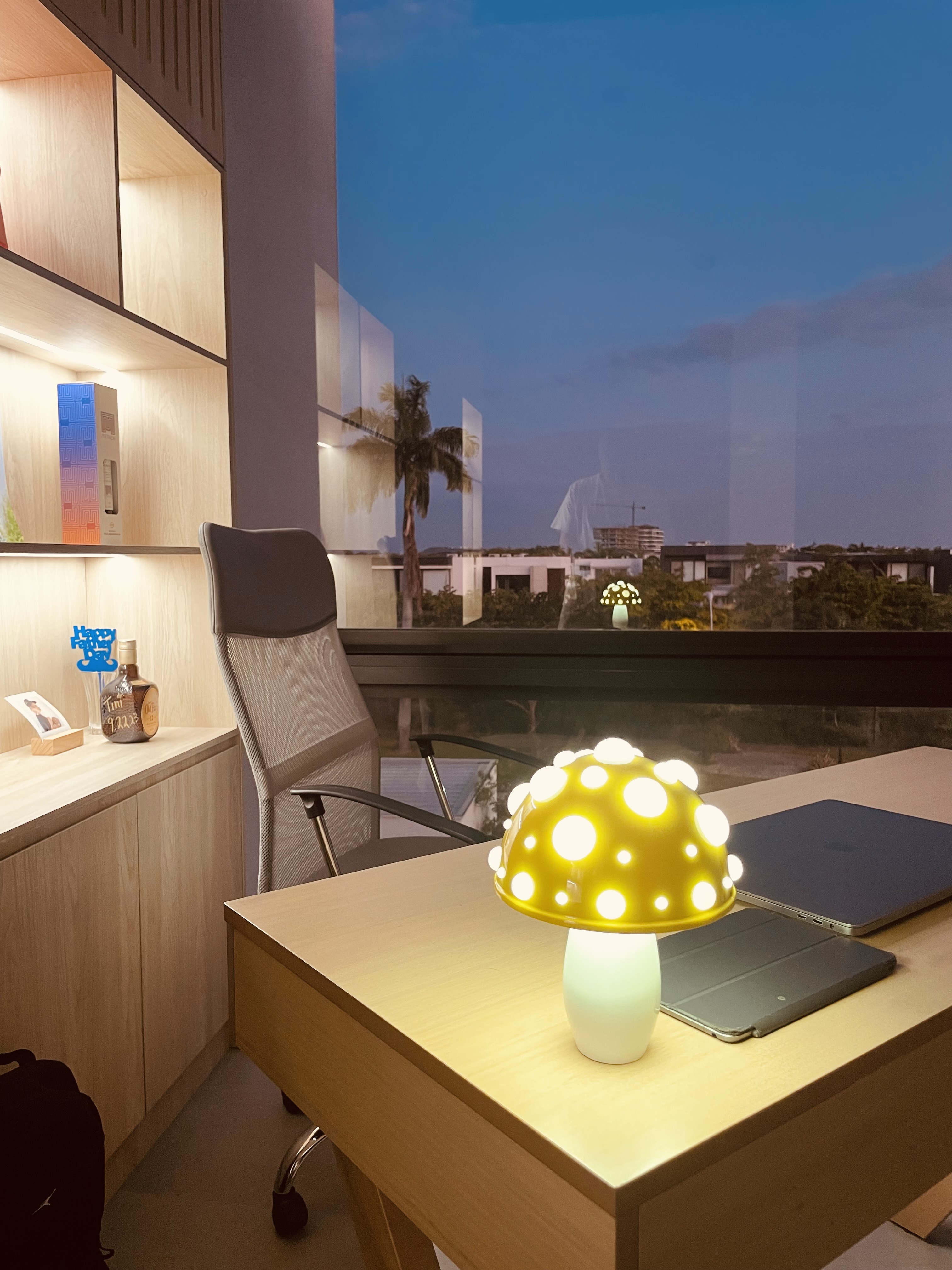 view of a desk with a lamp on it and a chair behind it