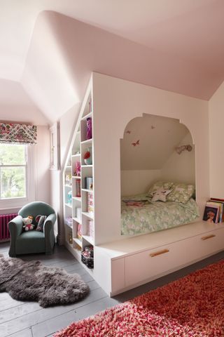 A cabin bed and walls in a light pink color