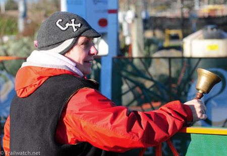 An official ringing the official bell for the final lap.