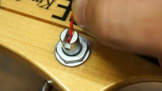 Feeding a string end into a bass guitar tuner