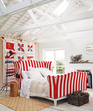 An example of bed ideas showing a red and white stripe bed in a white bedroom with a coastal theme
