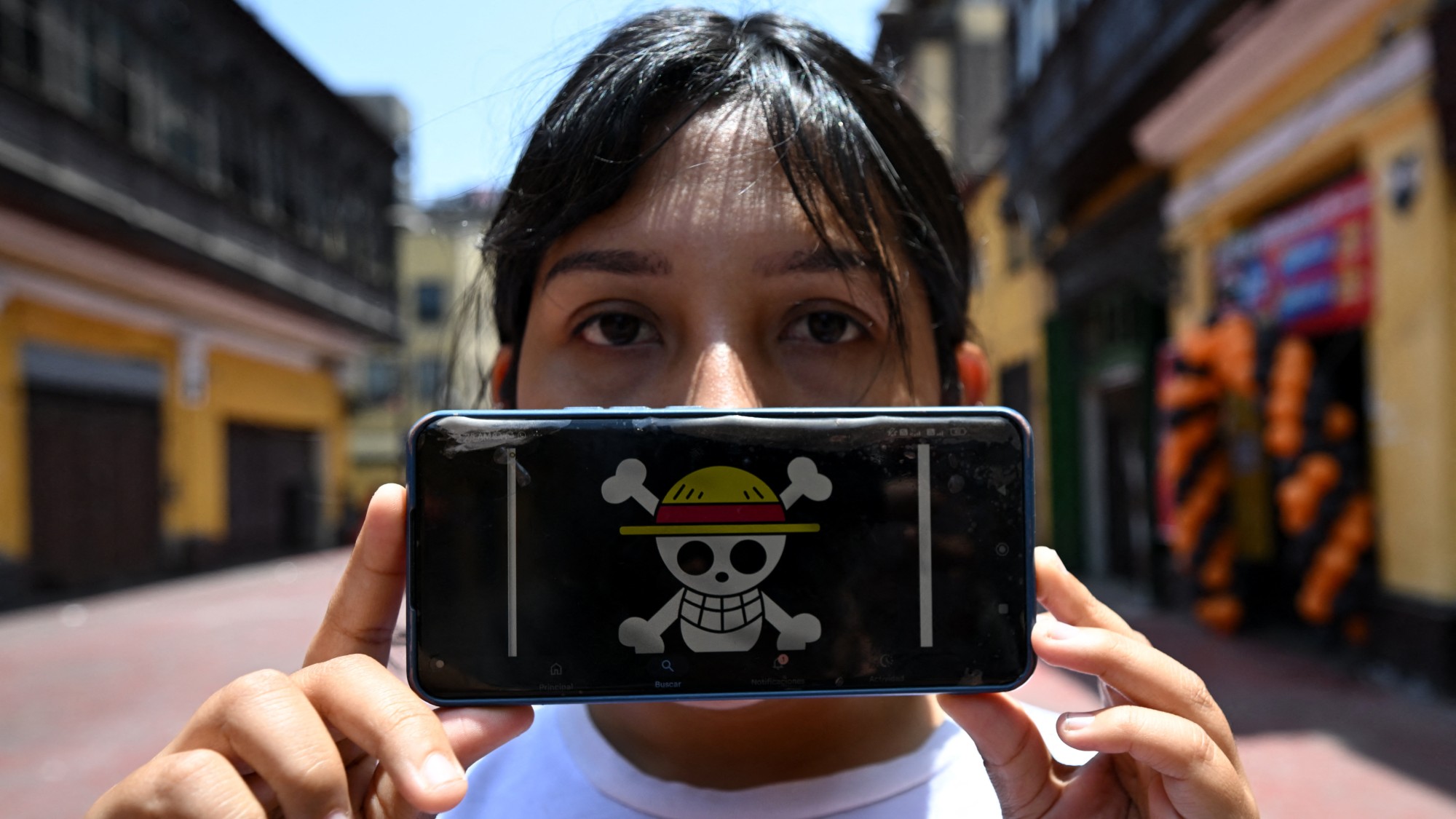 Peruvian law graduate Rosalinda,26, of the Gen Z movement, shows the One Piece manga flag on her mobile phone