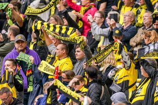 Supporters of Borussia Dortmund sing You Never Walk Alone and hold up their scarves during the Pre-season Friendly match between Borussia Dortmund and Ajax at Signal Iduna Park on August 6, 2023 in Dortmund, Germany.