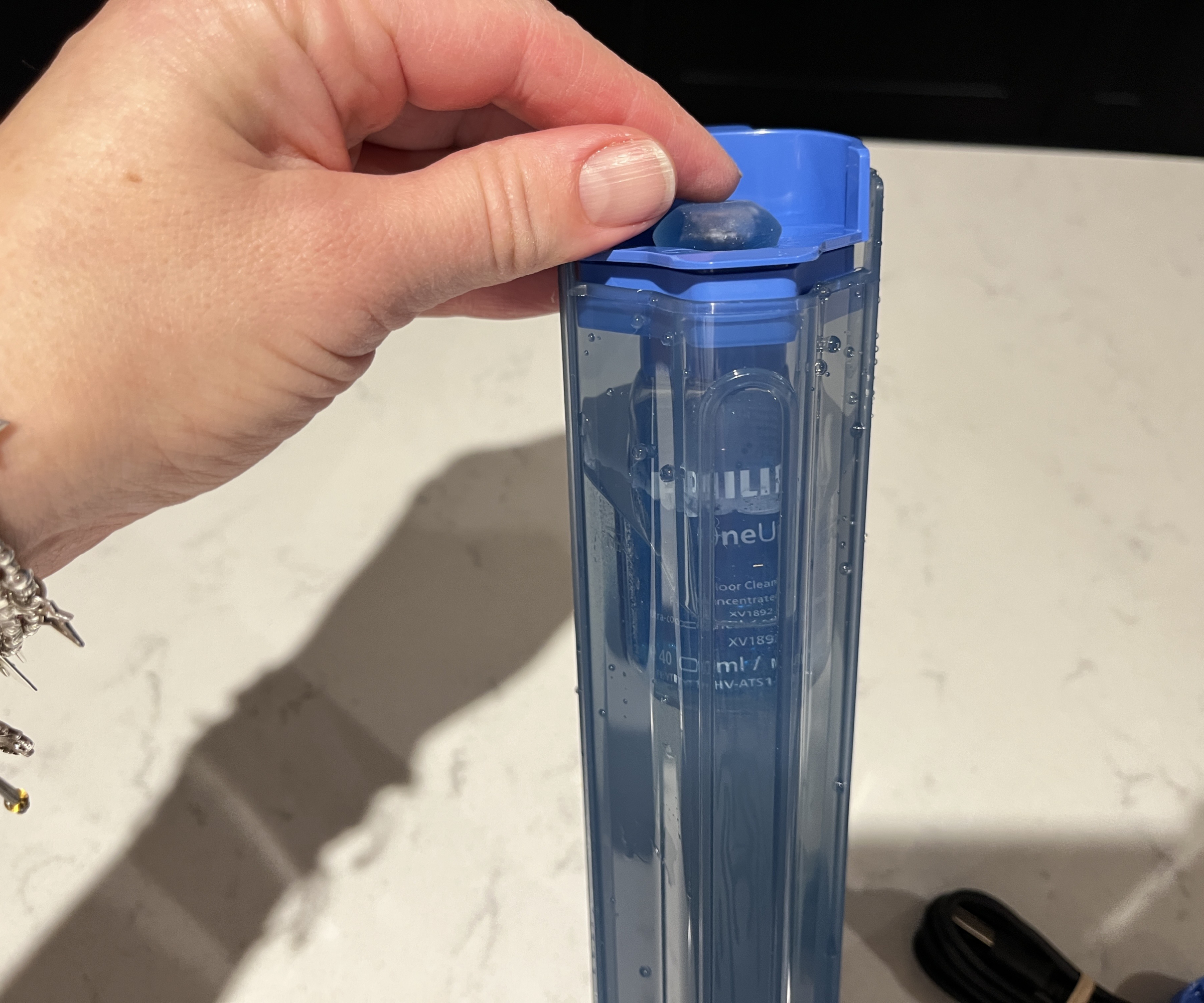 dispersing cleaning solution into the clean water tank on the Philips OneUP 5000 series electric mop