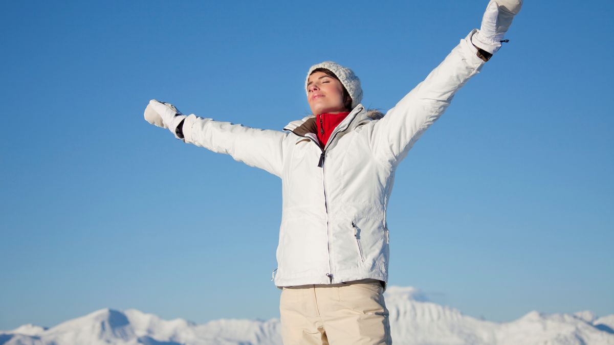 Woman in winter weather wearing mittens and padded jacket