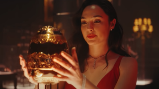 Sarah Black (Gal Gadot) looks pleased as she reaches for an elaborately jeweled egg in 'Red Notice'