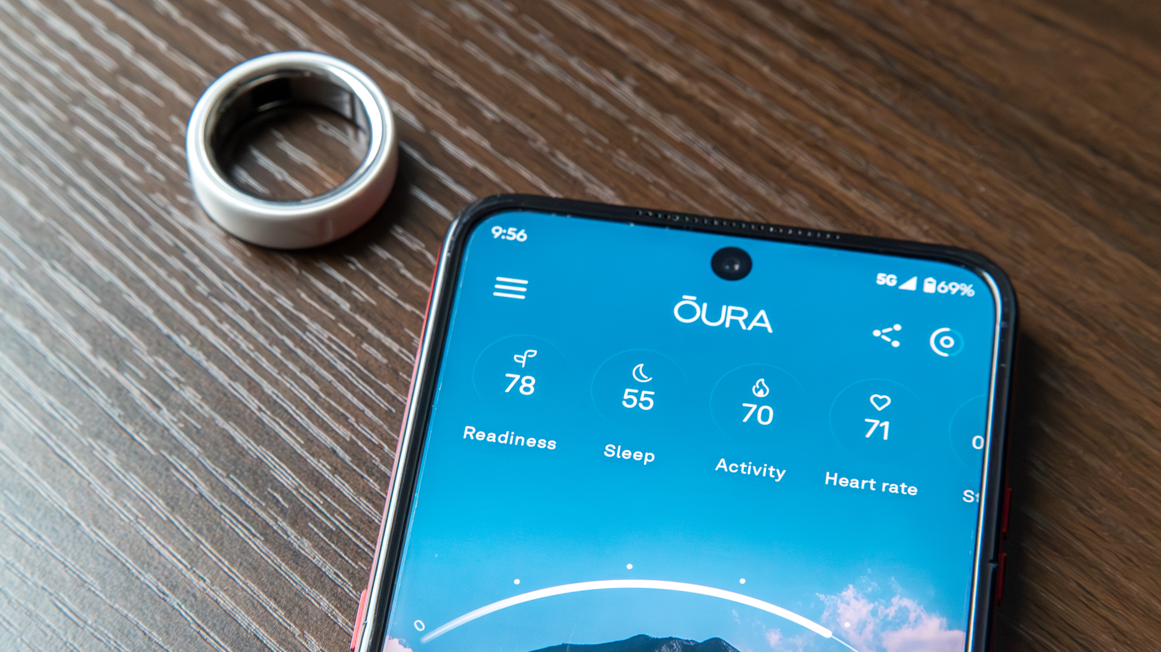 Oura Ring 4 Ceramic next to the Oura app