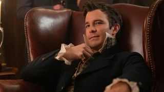 Benedict Bridgerton sits in a chair 