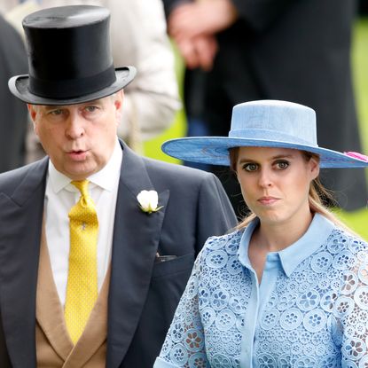 Prince Andrew wears a top hat and suit with a mustard yellow tie and tries to whistle while his daughter, Princess Beatrice, wears a light blue lace shirt dress with a wide-brimmed hat