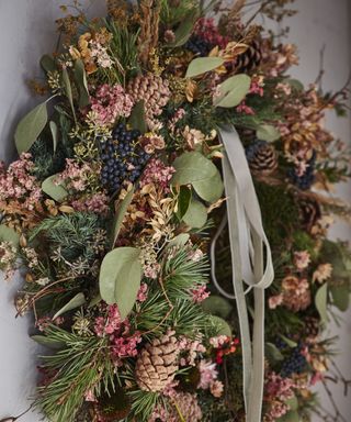 Thanksgiving wreath ideas with pine leaves and cones, black berries, branches and green foliage