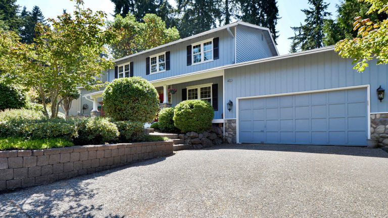 budget driveway ideas: driveway with blue garage door and retaining wall