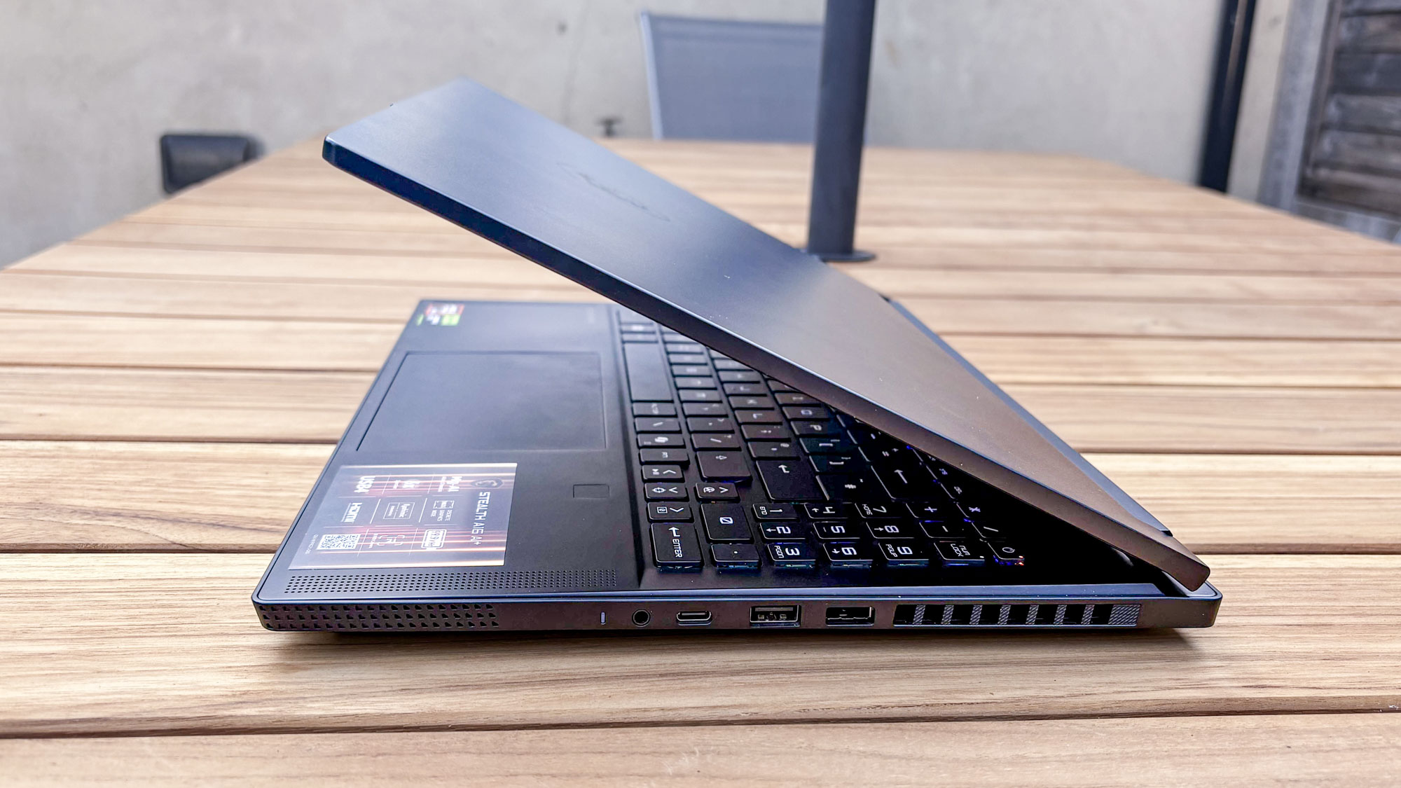 MSI Stealth A16 AI+ side view open halfway on garden table